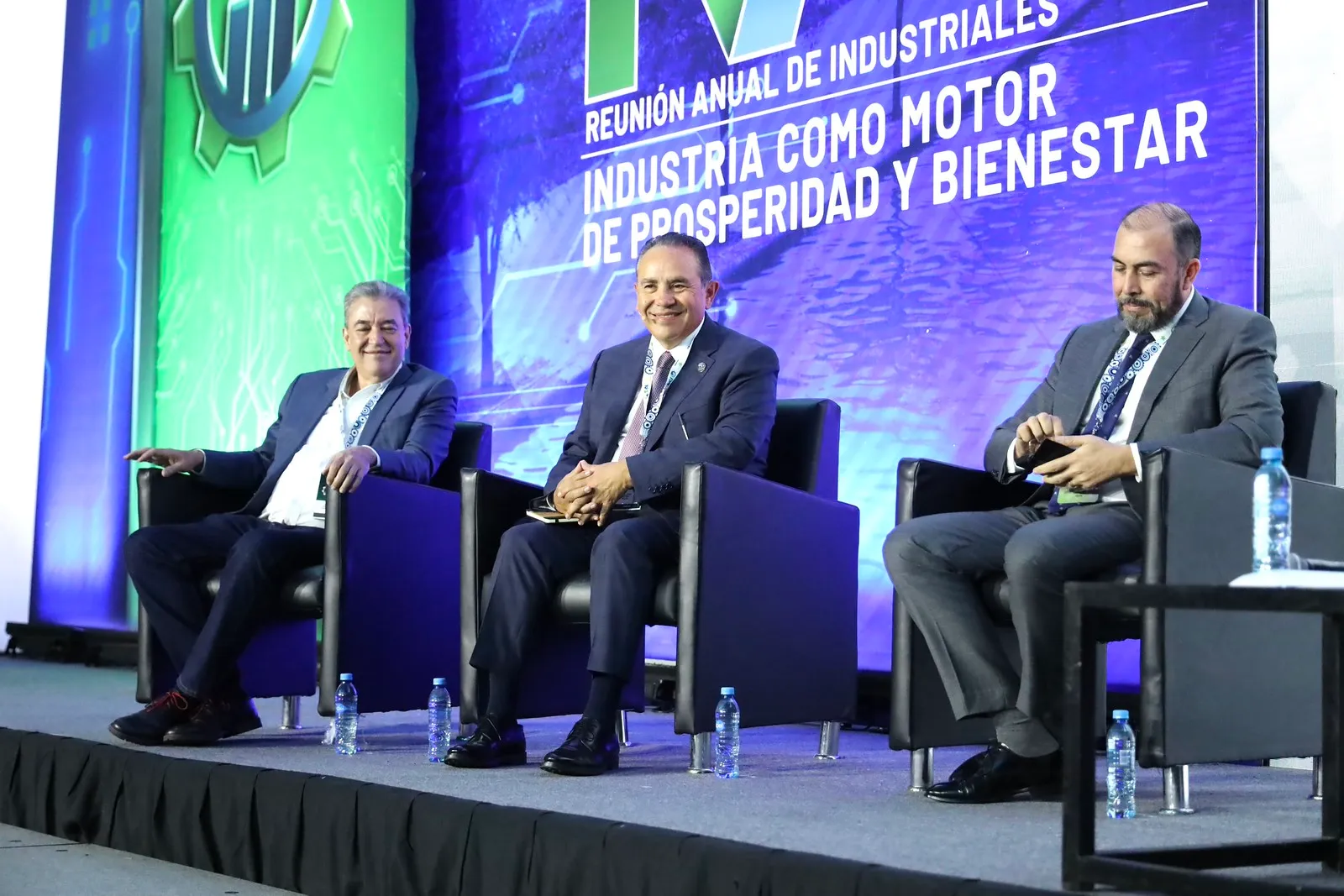 Panelistas conversando en el escenario